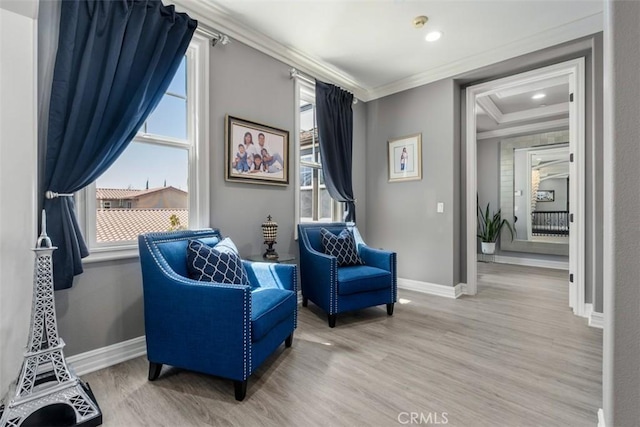 sitting room featuring crown molding, baseboards, and wood finished floors