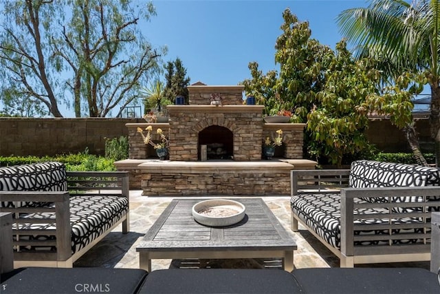 view of patio featuring fence and an outdoor living space with a fireplace