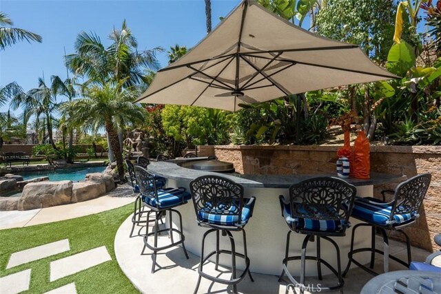 view of patio featuring a fenced in pool and outdoor dry bar