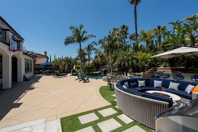 view of patio featuring an outdoor living space with a fire pit and an outdoor pool