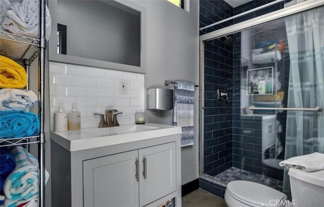 bathroom featuring vanity, decorative backsplash, a stall shower, and toilet