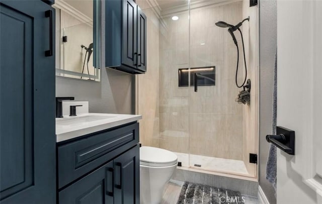 bathroom with crown molding, vanity, a stall shower, and toilet