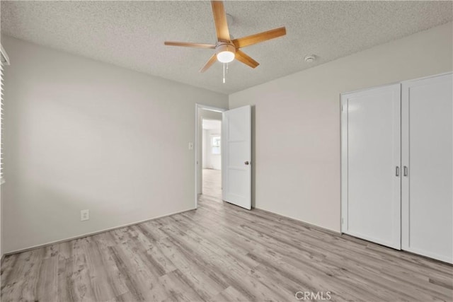 941 N Brand Blvd, San Fernando, CA 91340 - unfurnished bedroom with light wood finished floors, a textured ceiling, ceiling fan, and a closet