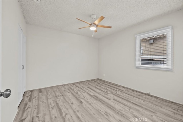 empty room featuring a textured ceiling, ceiling fan, and wood finished floors