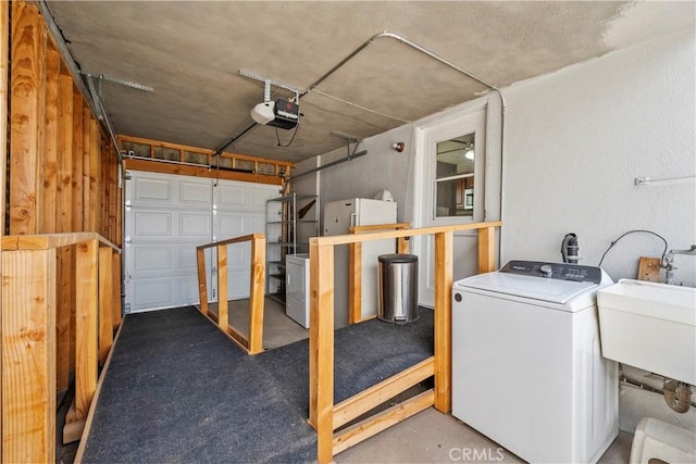 washroom with laundry area, a sink, washer / dryer, and a garage