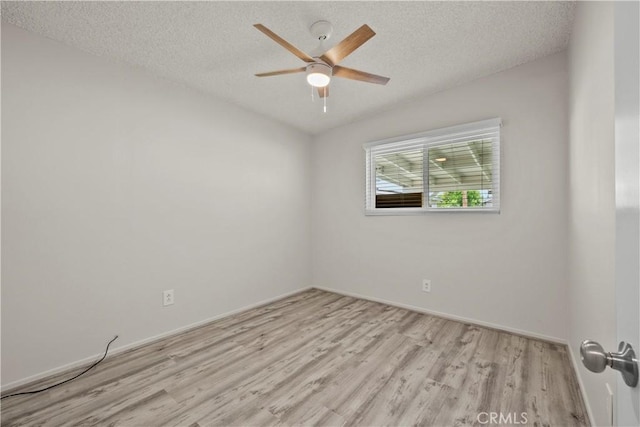 unfurnished room featuring baseboards, a ceiling fan, a textured ceiling, and wood finished floors