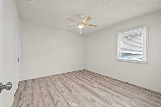 empty room with a textured ceiling, a ceiling fan, and wood finished floors
