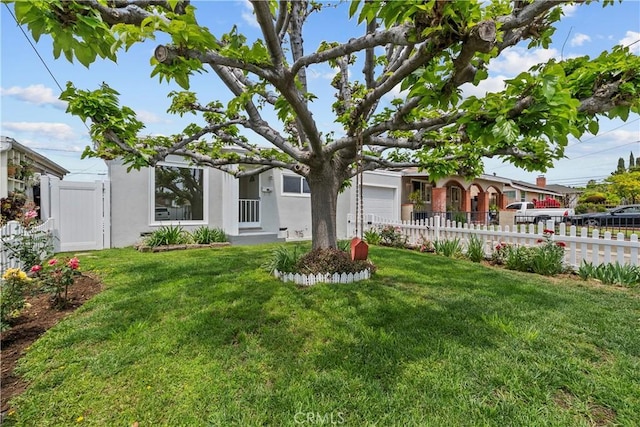 view of front facade with a garage, stucco siding, fence private yard, and a front lawn