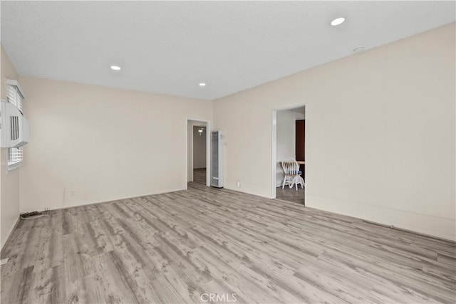 empty room with recessed lighting, wood finished floors, and a heating unit