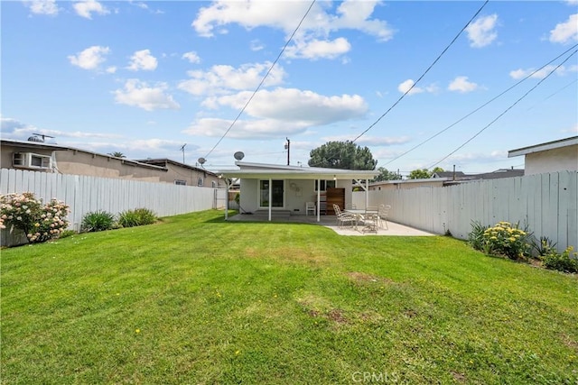 back of house featuring a lawn, a fenced backyard, and a patio area