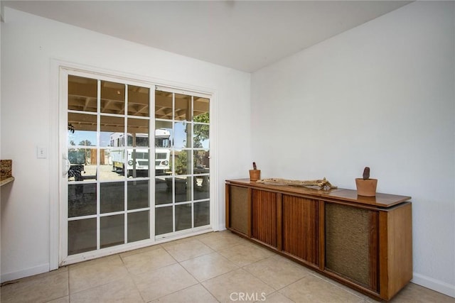 entryway with baseboards and light tile patterned floors