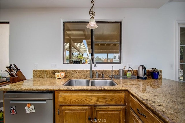 kitchen with light stone counters, a sink, dishwasher, brown cabinetry, and decorative light fixtures