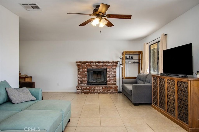 living area featuring visible vents, a brick fireplace, ceiling fan, and light tile patterned floors