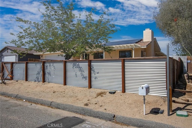 5750 Hall Ln Unit 29, Palms, CA 92277 - view of front of home with a chimney, stucco siding, and solar panels