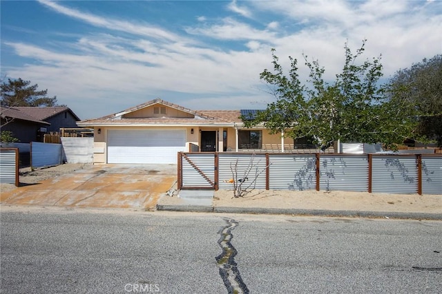 5750 Hall Ln Unit 29, Palms, CA 92277 - view of front facade with an attached garage, a tiled roof, stucco siding, concrete driveway, and a fenced front yard