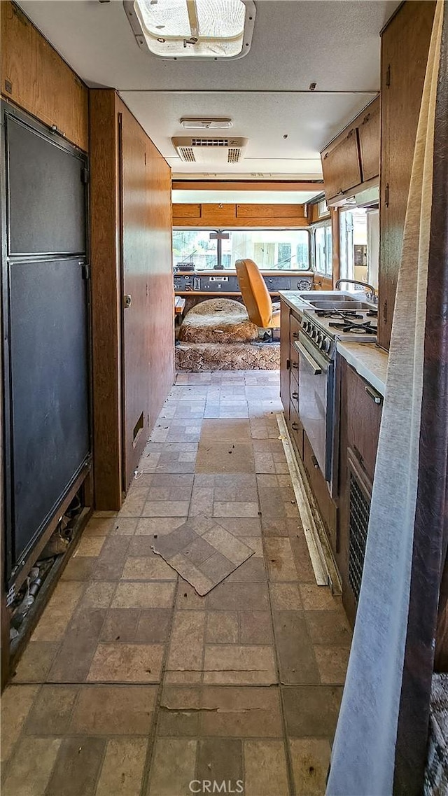 corridor featuring stone finish flooring and visible vents