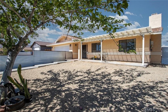 ranch-style house featuring stucco siding, fence, a chimney, and a garage