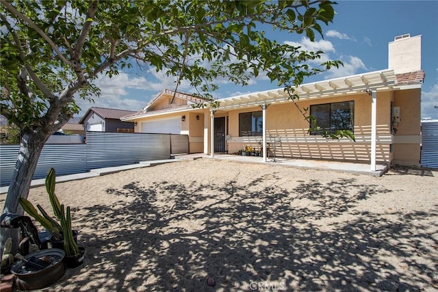 5750 Hall Ln Unit 29, Palms, CA 92277 - view of front of property featuring stucco siding, an attached garage, and a chimney