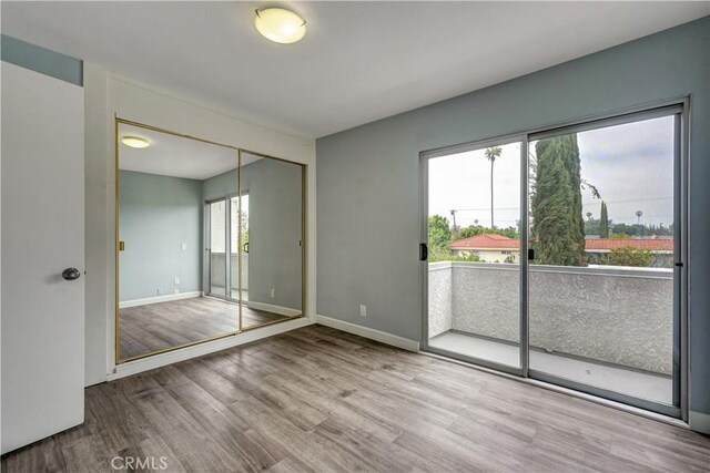 spare room featuring baseboards and wood finished floors