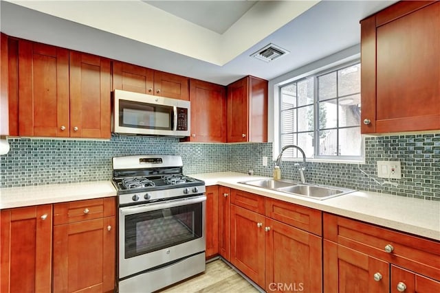 kitchen featuring visible vents, a sink, appliances with stainless steel finishes, and light countertops
