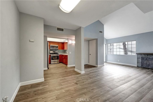 unfurnished living room featuring baseboards and light wood finished floors