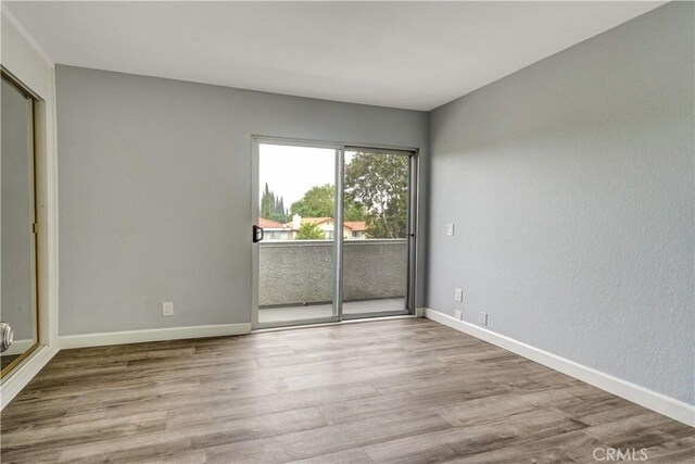 unfurnished room featuring baseboards and wood finished floors