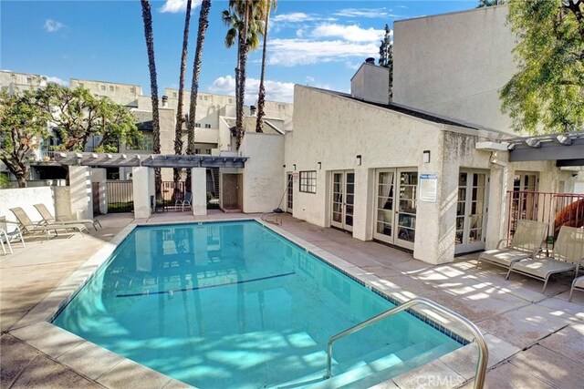 community pool featuring a patio, french doors, and a pergola