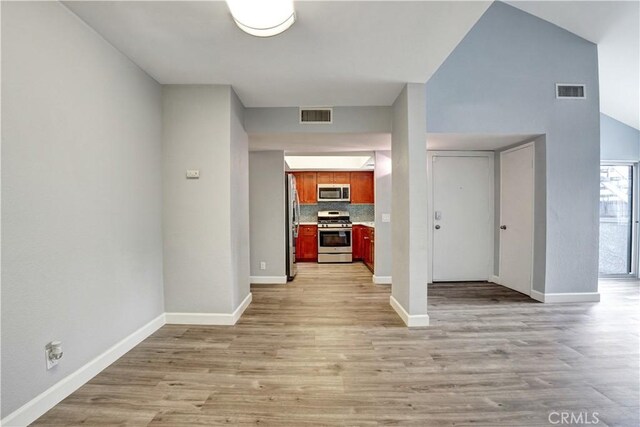 interior space with baseboards, visible vents, and light wood finished floors