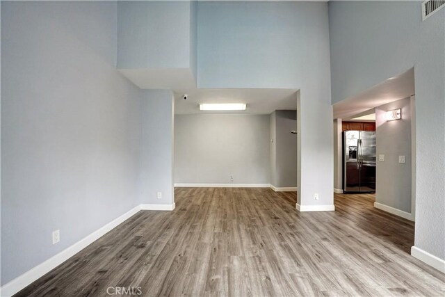 empty room featuring baseboards, visible vents, and wood finished floors