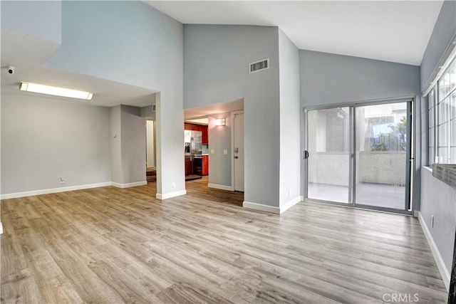 unfurnished living room with visible vents, baseboards, high vaulted ceiling, and light wood-type flooring