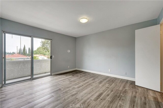 unfurnished room featuring baseboards and wood finished floors