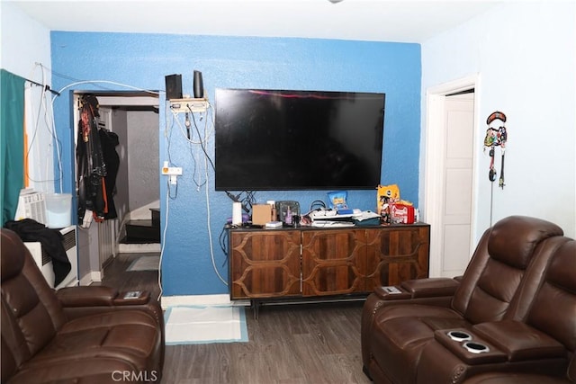 living room with baseboards, a textured wall, and wood finished floors