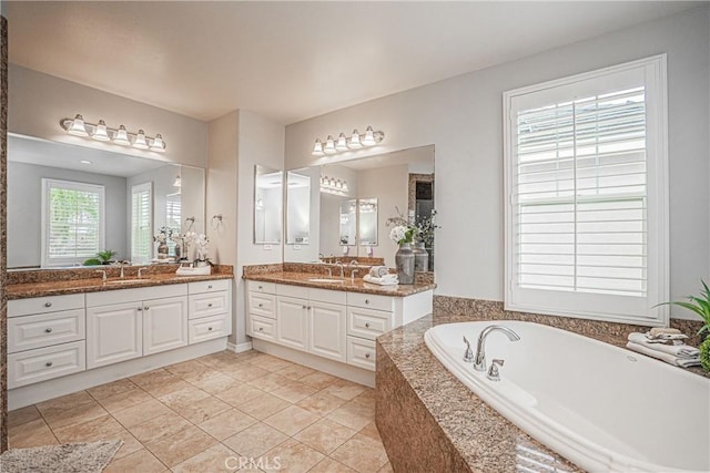 full bath with a garden tub, a sink, two vanities, and tile patterned floors