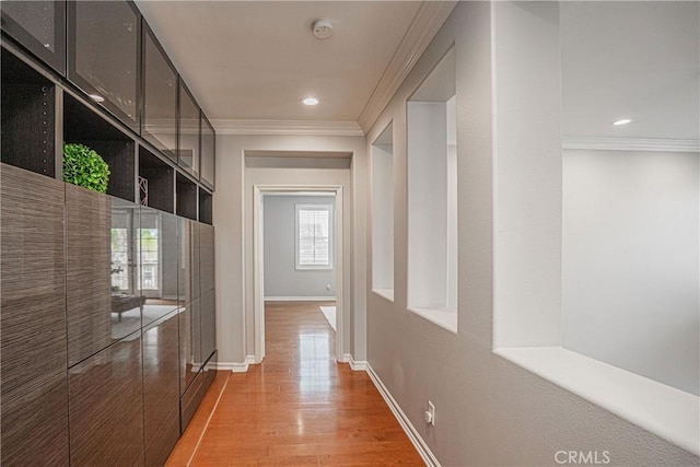 hallway with crown molding, baseboards, recessed lighting, and light wood-type flooring