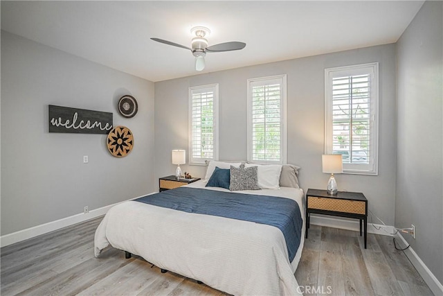 bedroom with baseboards, ceiling fan, and wood finished floors