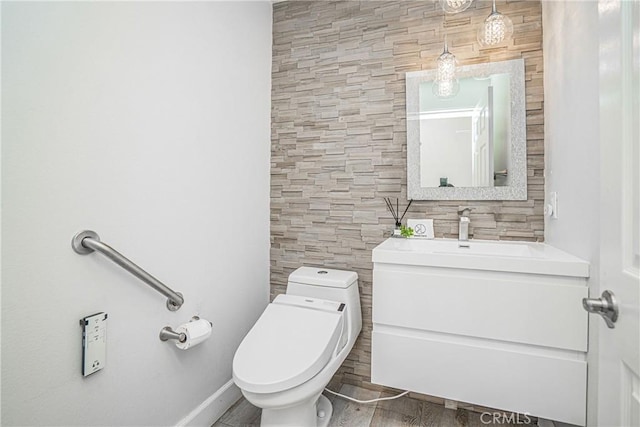 bathroom featuring vanity, wood finished floors, and toilet