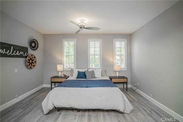 bedroom featuring baseboards, a ceiling fan, and wood finished floors