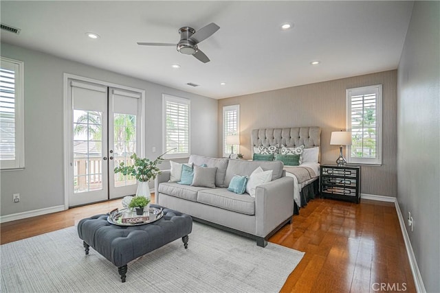 bedroom with baseboards, visible vents, access to exterior, and wood finished floors