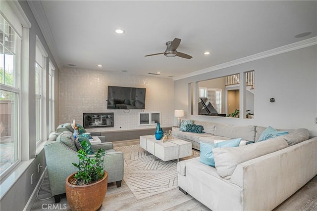 living area with crown molding, a ceiling fan, recessed lighting, and wood finished floors