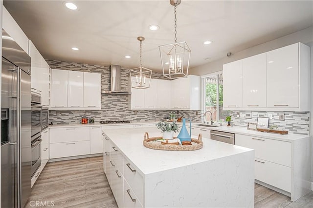 kitchen featuring a kitchen island, recessed lighting, modern cabinets, and wall chimney exhaust hood