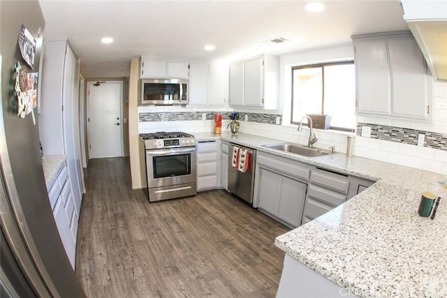 30830 Roan Ct, Tehachapi, CA 93561 - kitchen with dark wood-style flooring, appliances with stainless steel finishes, a sink, decorative backsplash, and visible vents