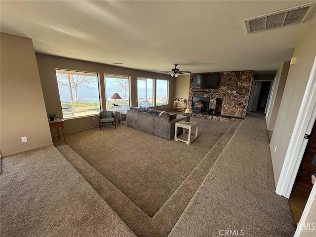 30830 Roan Ct, Tehachapi, CA 93561 - carpeted living room featuring visible vents, baseboards, ceiling fan, and a fireplace