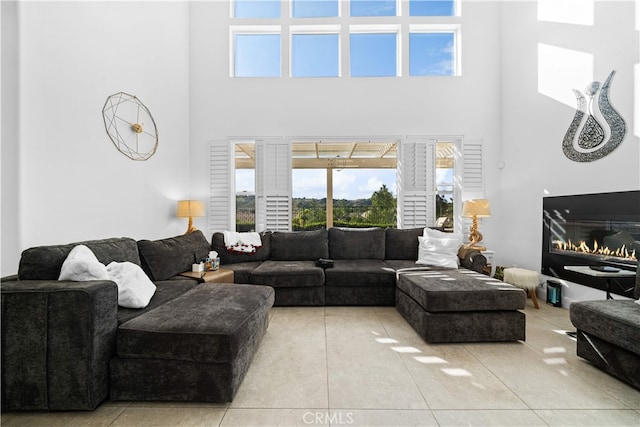 5 Westchester Ct, Coto De Caza, CA 92679 - living room featuring a high ceiling, light tile patterned floors, healthy amount of natural light, and a glass covered fireplace