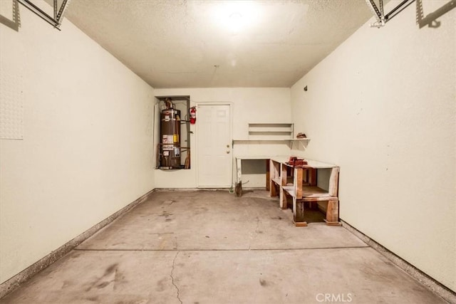 garage with baseboards and water heater