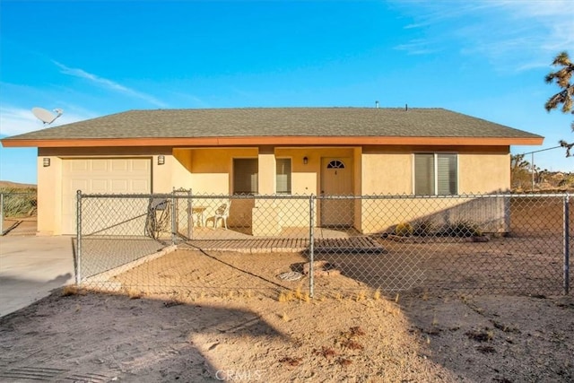 ranch-style house with roof with shingles, fence private yard, concrete driveway, an attached garage, and stucco siding