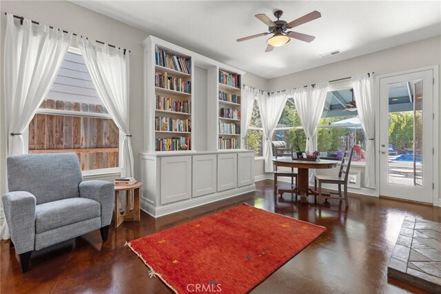 living area with visible vents and ceiling fan