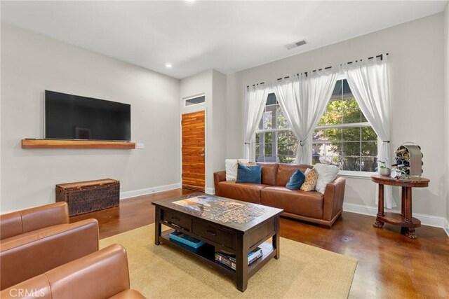 living area featuring baseboards, concrete floors, recessed lighting, and visible vents