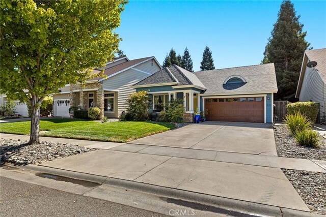 view of front facade featuring fence, a front lawn, concrete driveway, an attached garage, and a shingled roof