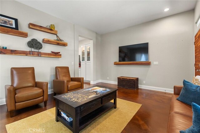 living area featuring recessed lighting, baseboards, and finished concrete flooring