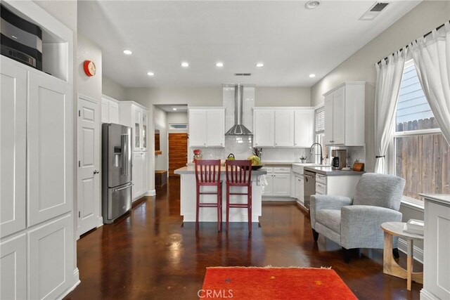 kitchen featuring appliances with stainless steel finishes, tasteful backsplash, recessed lighting, and wall chimney exhaust hood
